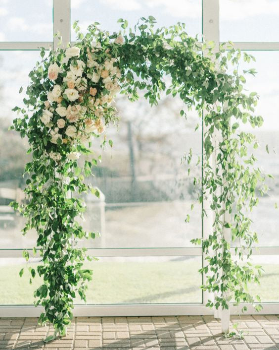 Smilax vine cascading from arbor for romantic wedding ceremony.