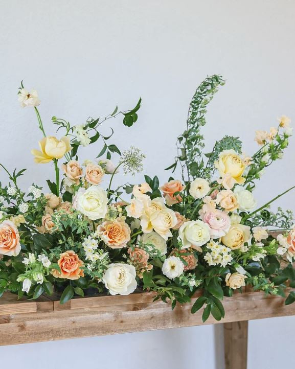 Floral arrangement on a wooden table with a white background