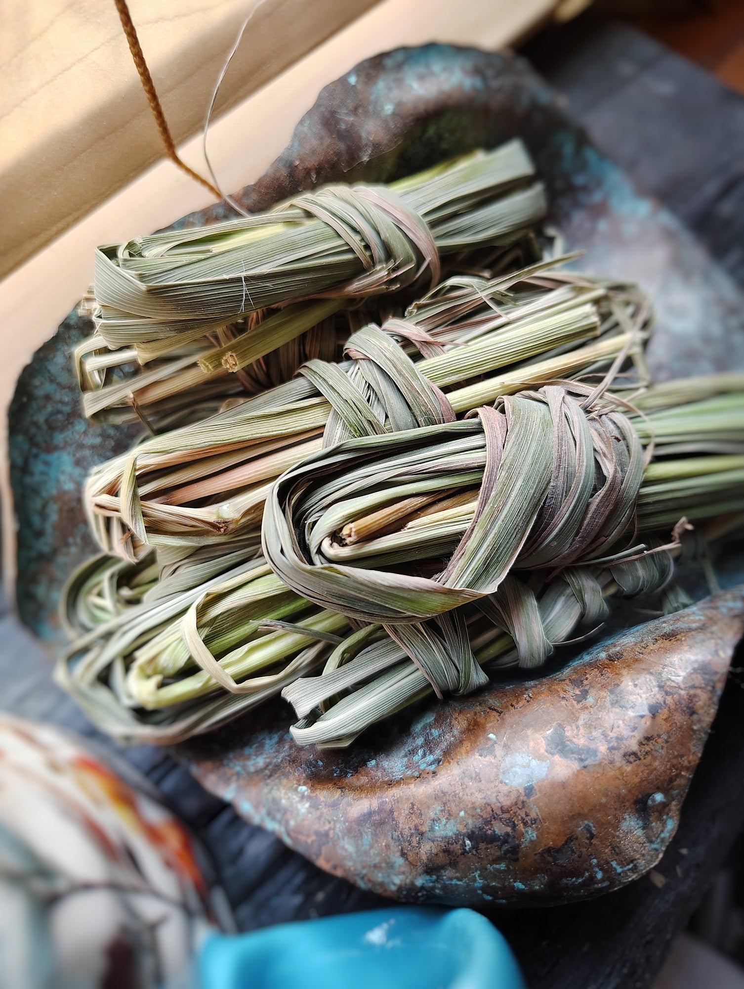 Bundles of dried herbs tied together on a rustic stone surface