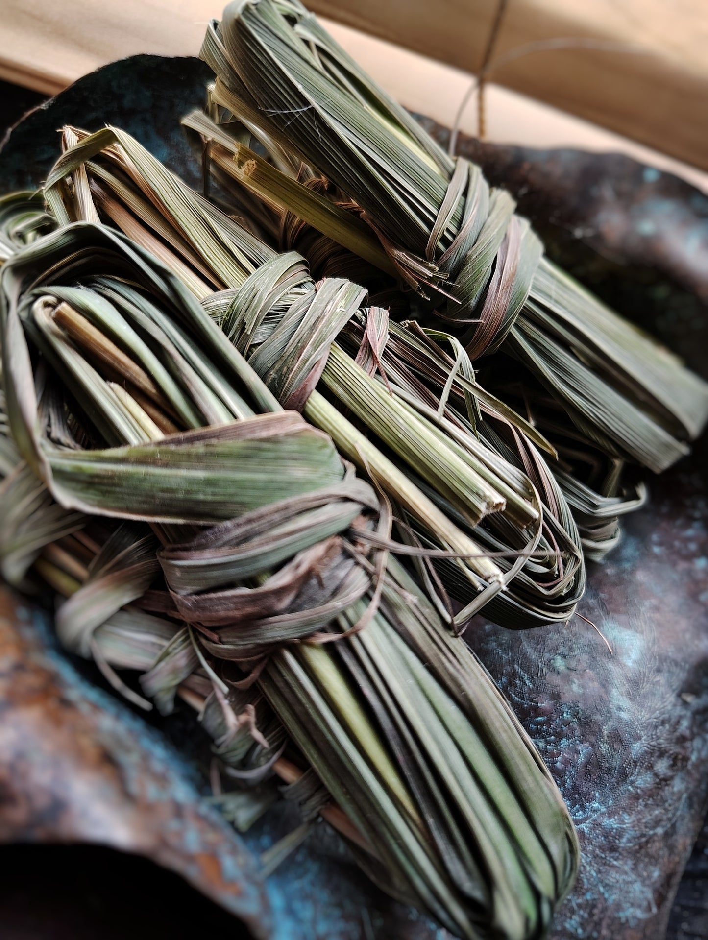 Bundles of dried lemongrass tied together on a dark surface